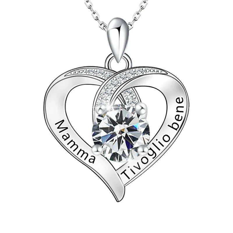 Silver heart-shaped pendant with a central gemstone and engraved text on a white background