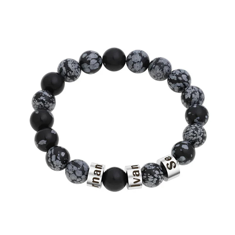 A men’s snowflake stone beaded bracelet with customizable black engraved name rings, designed for a bold and stylish look.