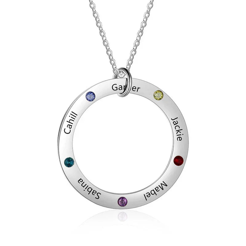 A sterling silver circle pendant necklace engraved with names and adorned with colorful birthstones on a delicate chain.