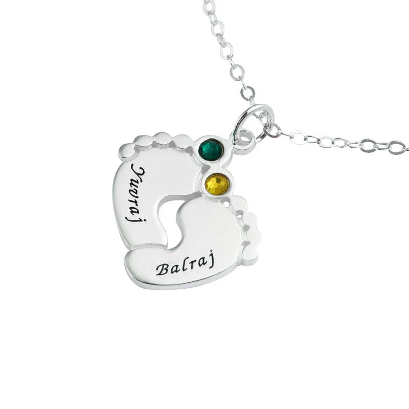 Silver baby feet necklace with two birthstones and engraved names.
