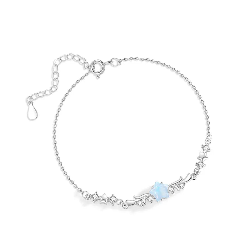 Delicate silver bracelet with star and zircon details featuring a central blue gemstone on a white background.