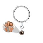 Keychain with a heart-shaped photo charm and a round brown gemstone on a white background