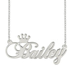 A silver personalized name necklace featuring the name “Bailey” in elegant cursive script, with a small crown design above the first letter.