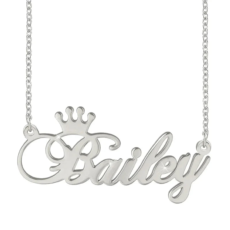 A silver personalized name necklace featuring the name “Bailey” in elegant cursive script, with a small crown design above the first letter.