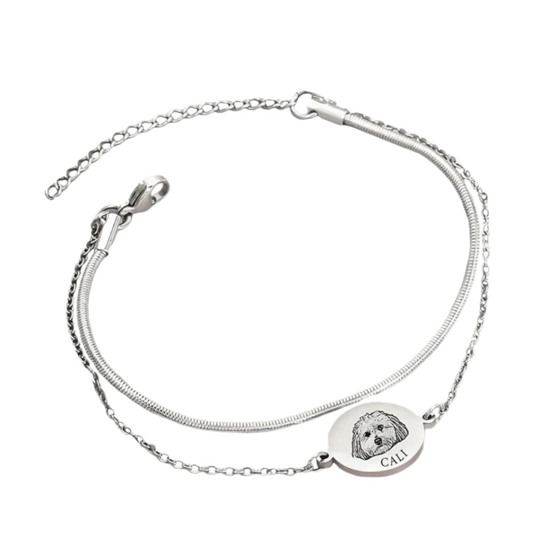 Silver bracelet with a round charm featuring an engraved face and the name 'Cali' on a white background.