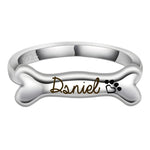 Silver bone-shaped ring with 'Dsniel' engraving on a white background