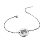 Silver bracelet with a round tag featuring a cat illustration and engraved text on a white background