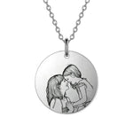 Silver necklace with a round pendant featuring an engraved illustration of two people embracing.