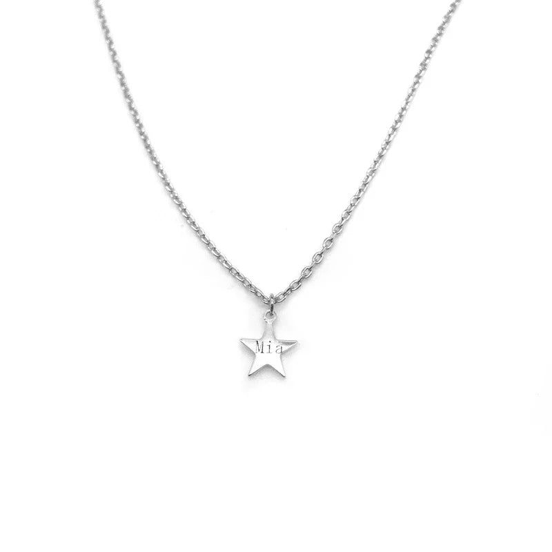 A minimalist silver necklace featuring a small engraved star pendant with the name ‘Mia’ inscribed on it, displayed on a white background.