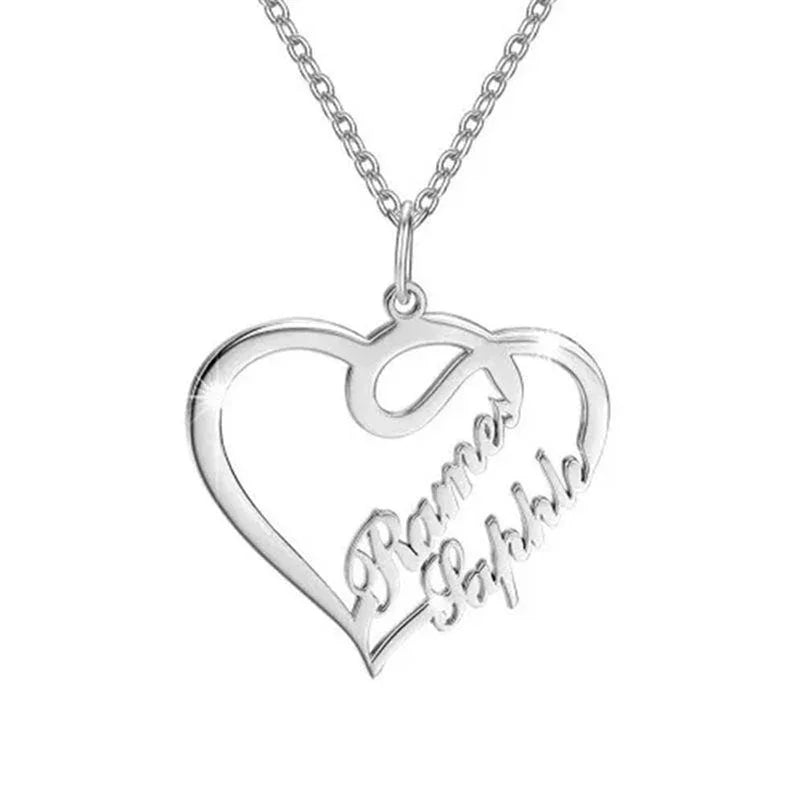 Silver heart-shaped necklace with two engraved names and an infinity-inspired design hanging from a delicate chain.