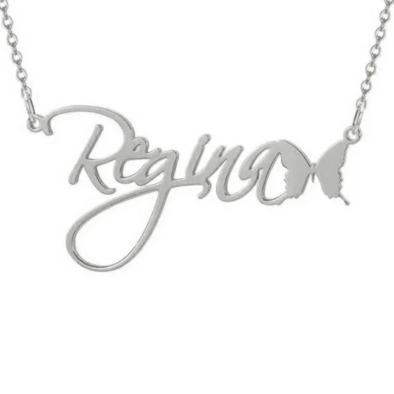 A personalized silver necklace featuring the name “Regina” in elegant cursive lettering, ending with a detailed butterfly shape that connects to the chain, symbolizing grace and transformation.