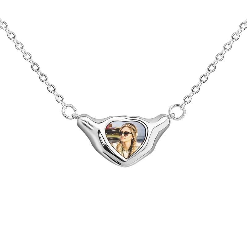 Silver necklace with a heart-shaped pendant featuring a photo of a woman.