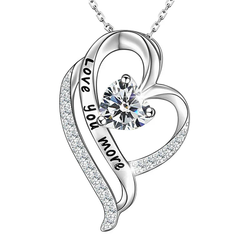 Silver heart-shaped necklace engraved with “Love you more,” featuring a sparkling heart-cut birthstone at the center.