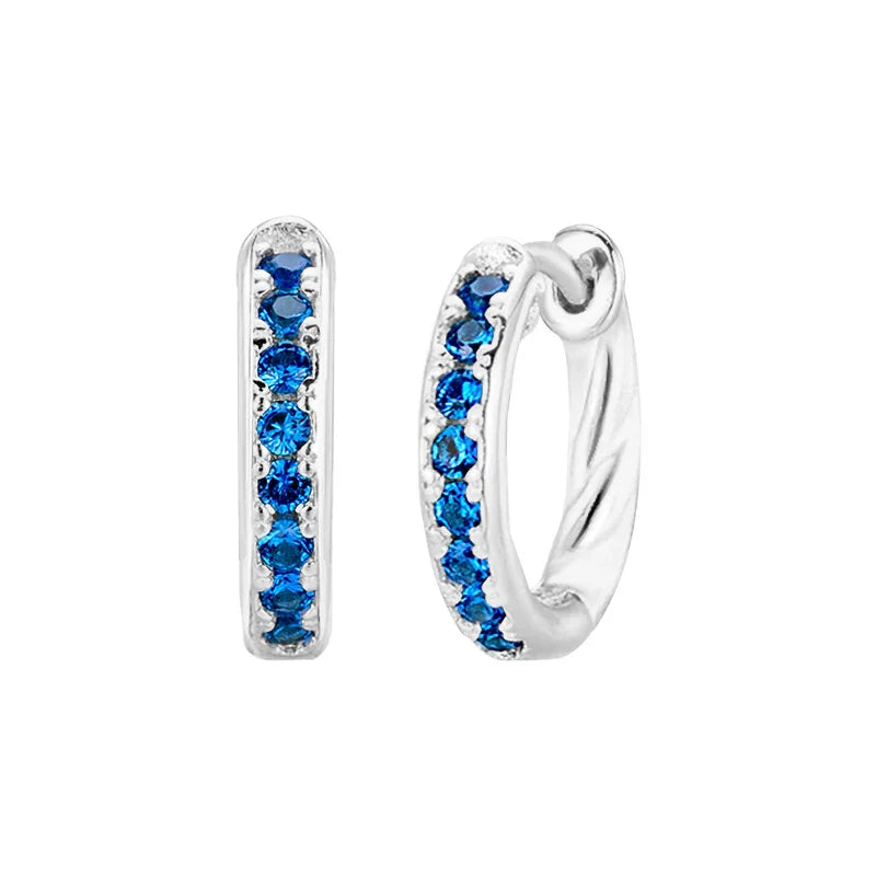 Silver hoop earrings with blue gemstones on a white background