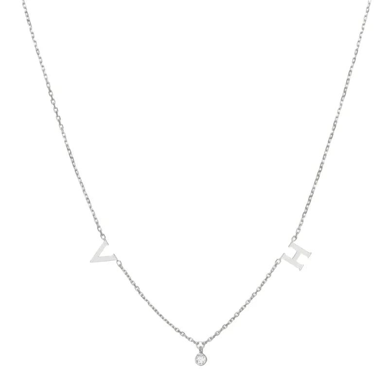 A delicate silver necklace featuring two letter charms and a small round gemstone pendant in the center, creating a minimalist and elegant design.