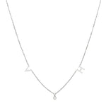A delicate silver necklace featuring two letter charms and a small round gemstone pendant in the center, creating a minimalist and elegant design.