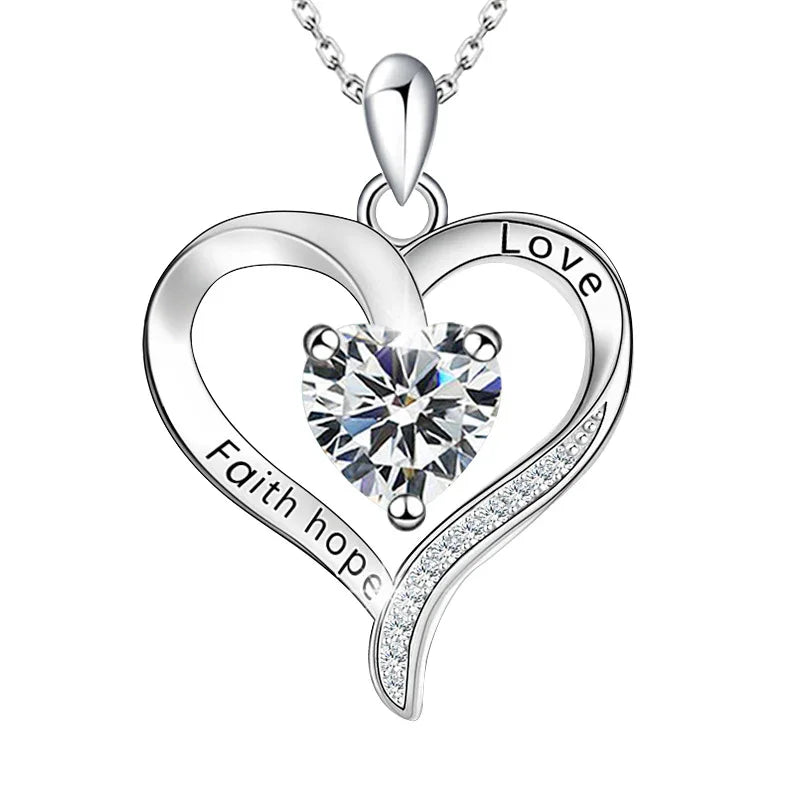 Silver heart-shaped birthstone necklace engraved with “Faith Hope Love,” featuring a central sparkling stone symbolizing belief, hope, and love.