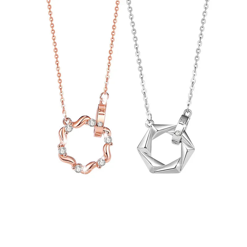 A pair of couple necklaces displayed on a white background. The left necklace features a rose gold circular pendant adorned with small sparkling gemstones and a matching rose gold chain. The right necklace has a silver hexagonal pendant with geometric facets and a silver chain, creating a romantic and modern contrast.