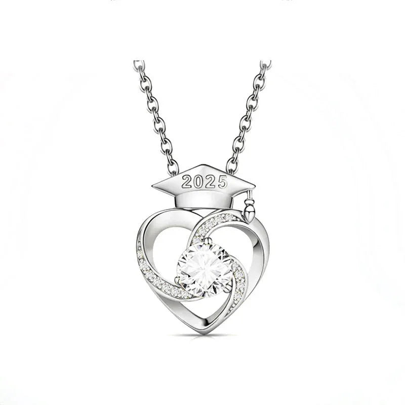 Silver necklace with a heart-shaped pendant, sparkling center stone, and a graduation cap engraved with 2025