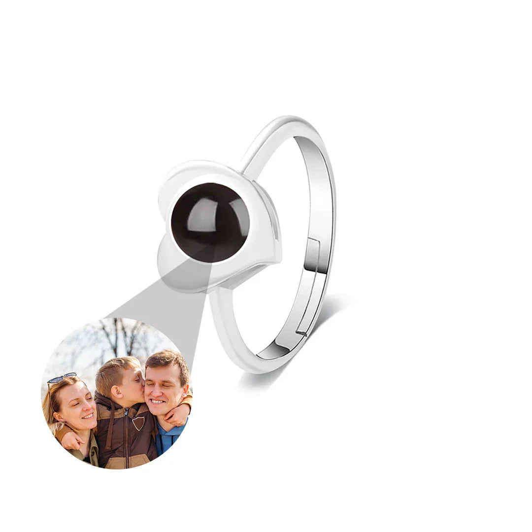 Silver ring with a black gemstone and circular photo insert on a white background