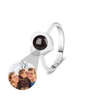 Silver ring with a black gemstone and circular photo insert on a white background