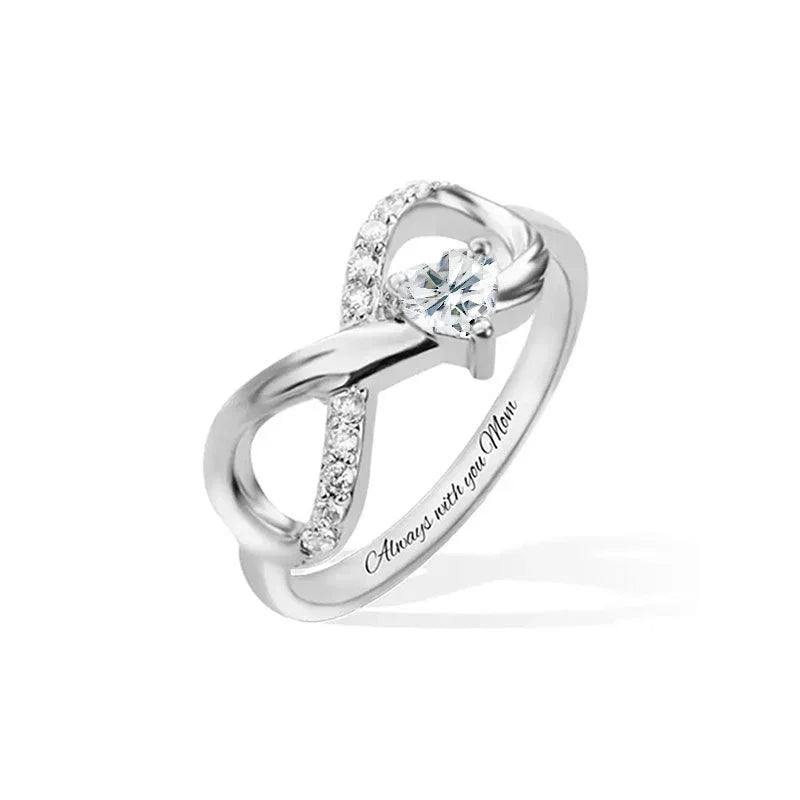 Silver infinity-style ring with a central clear gemstone and engraved message along the band.