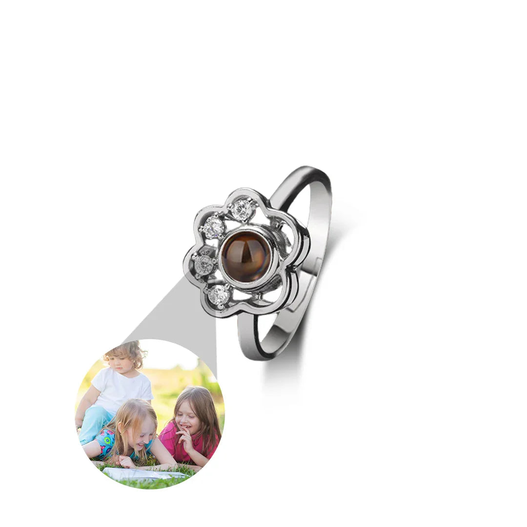 Silver ring with a brown gemstone and a photo of two children on a white background