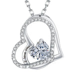 Silver double-heart pendant featuring a central heart-shaped gemstone and engraved text that reads “I love you,” displayed on a white background.