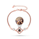 Rose gold bracelet with a photo charm on a white background
