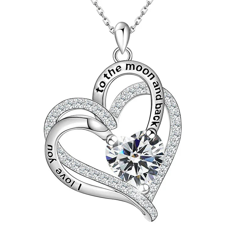 Silver double-heart pendant featuring a central heart-shaped gemstone and engraved text reading “I love you to the moon and back,” displayed on a white background.