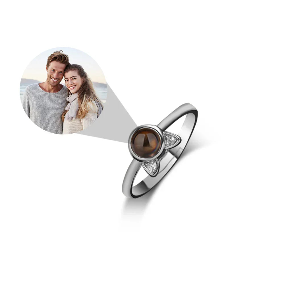 Silver ring with a brown gemstone and heart design on a white background