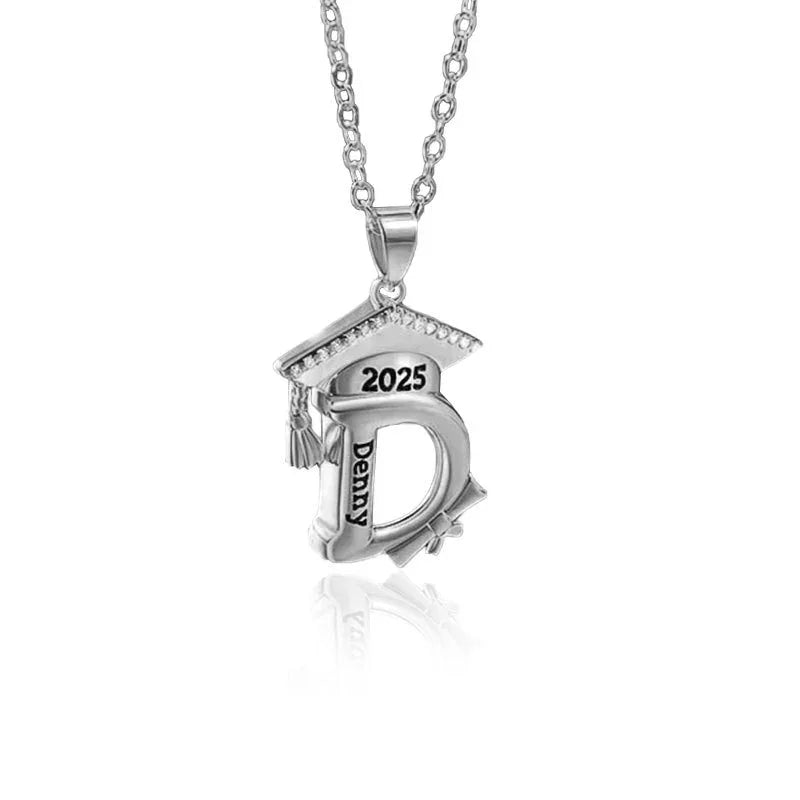 Silver necklace with a 2025 graduation cap and personalized initial pendant engraved with the name Denny.