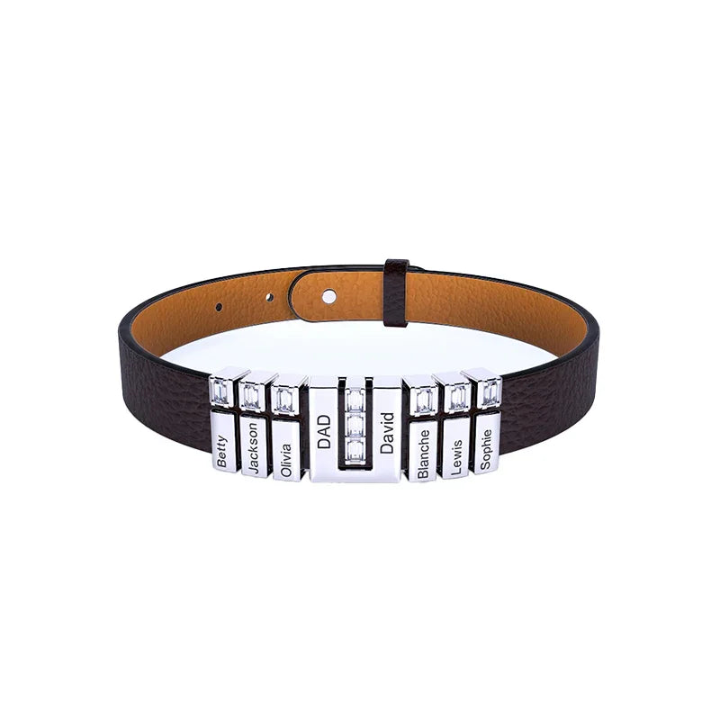 A men’s bracelet with a dark brown leather strap and multiple shiny silver rectangular nameplate beads. The central bead is slightly larger with decorative crystal-like accents, while the surrounding beads are sleek and evenly spaced along the strap. The bracelet has an adjustable buckle closure for a secure fit.