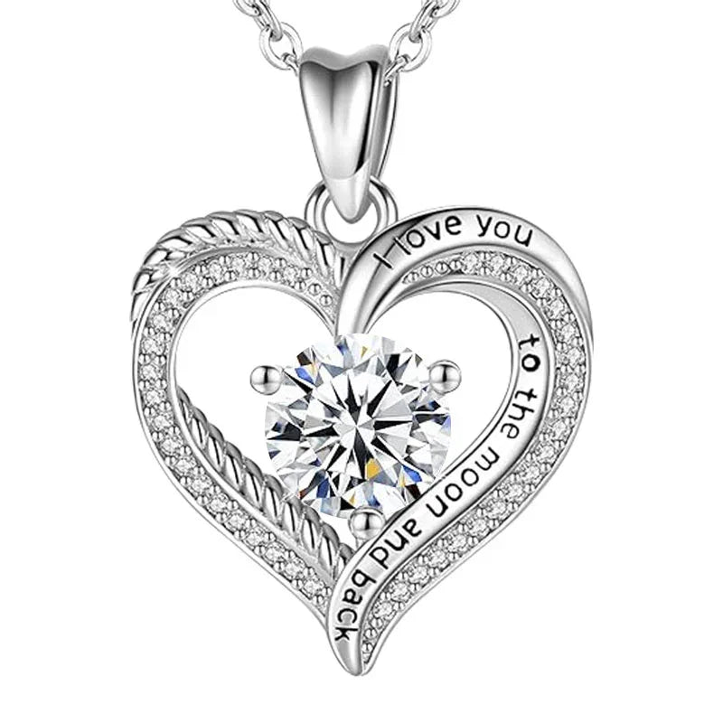 Silver heart-shaped pendant featuring a central round gemstone and engraved text that reads “I love you to the moon and back,” displayed on a white background.