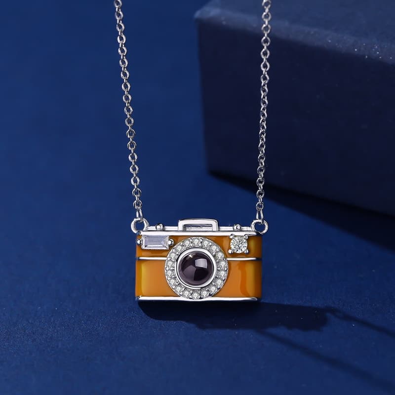 Camera-shaped pendant necklace on a blue background