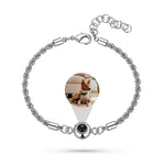 An 18k plated rope chain bracelet with an adjustable clasp and a custom photo pendant featuring a dog.