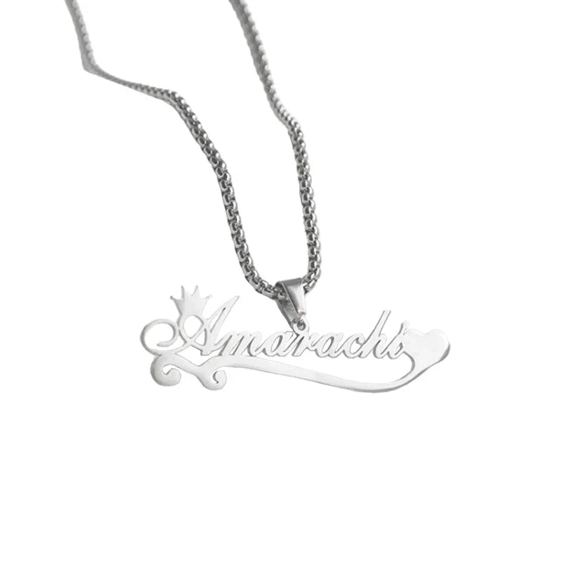 A personalized silver necklace featuring the name “Amarachi” in elegant cursive script, accented with a small crown above the first letter and a heart at the end, hanging from a polished silver chain.
