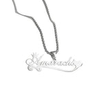 A personalized silver necklace featuring the name “Amarachi” in elegant cursive script, accented with a small crown above the first letter and a heart at the end, hanging from a polished silver chain.