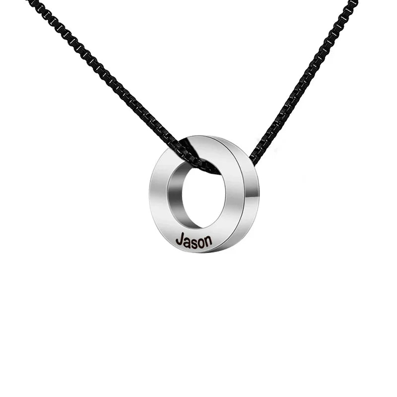 A stainless steel necklace featuring a polished circular geometric pendant engraved with the name “Jason,” strung on a black chain, symbolizing simplicity and personalized modern style.