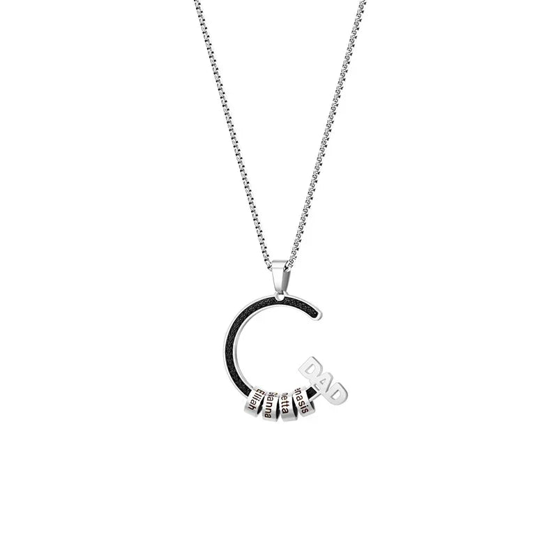 A stainless steel necklace featuring a semi-circle pendant with the word “DAD” and several engraved name beads, symbolizing family love and connection in a sleek, modern design.