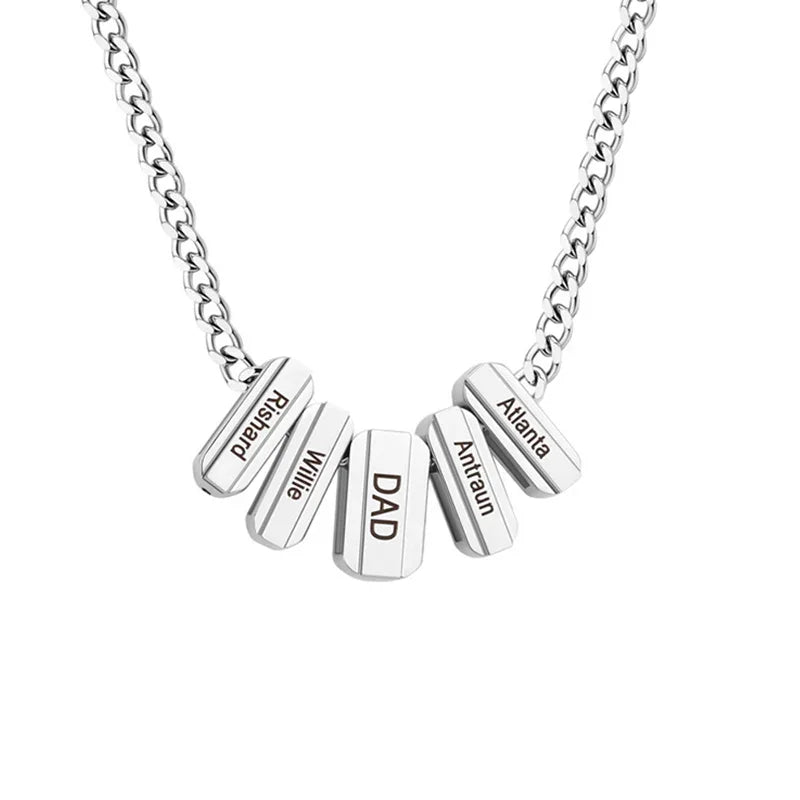 A stainless steel necklace featuring multiple rectangular bar pendants engraved with names such as “DAD,” “Willie,” and “Atlanta,” symbolizing family connection and personalized style.