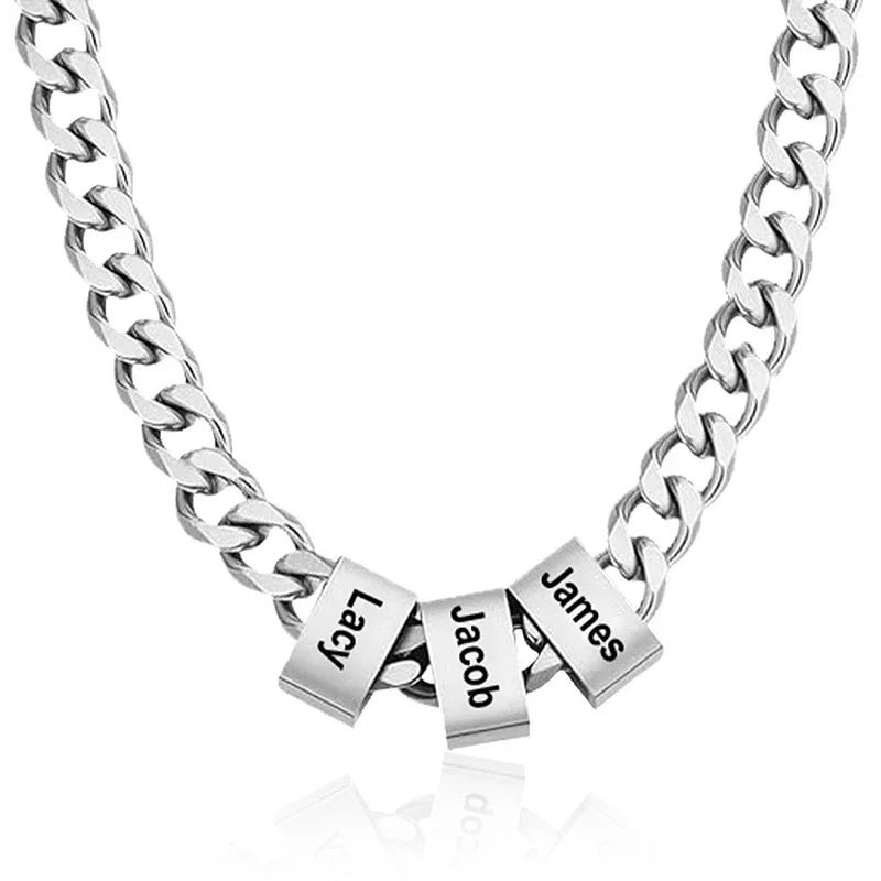 A stainless steel men’s necklace featuring a thick chain with three engraved square beads labeled “Lacy,” “Jacob,” and “James,” symbolizing personalized style and family connection.