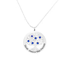 A silver Tree of Life necklace featuring a circular pendant engraved with the names “Sarah,” “Jessica,” “Max,” and “Pamela.” The pendant’s intricate tree design is adorned with multiple blue gemstones, hanging from a delicate silver chain against a plain white background.