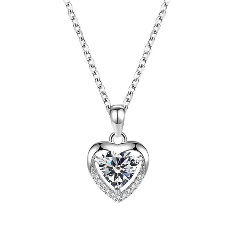 Heart-shaped silver pendant with clear gemstone on a white background