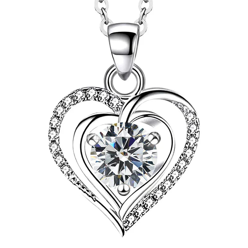 A silver heart-shaped necklace with a sparkling round gemstone at the center, accented with small crystals along the curves, symbolizing elegant love and devotion.