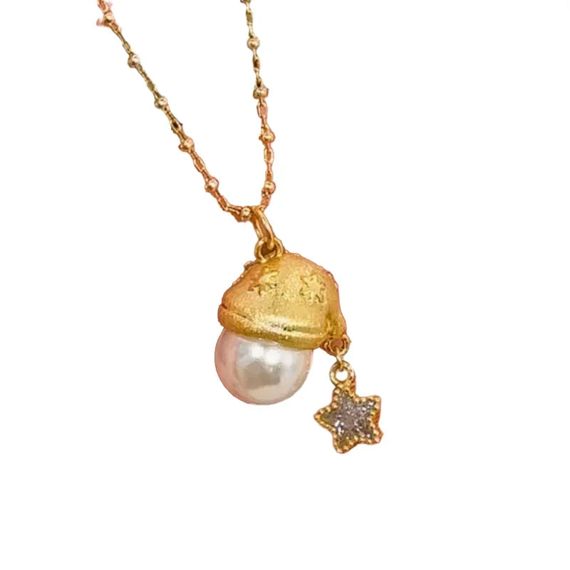 A festive pendant necklace featuring a small gold Santa hat with star engravings, a single round pearl accent, and a dangling star charm with sparkling crystal details. The pendant hangs from a delicate gold chain, creating a whimsical holiday look.
