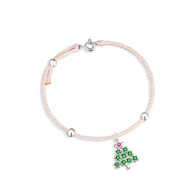 A delicate Christmas-themed bracelet featuring a braided white cord, accented with small silver beads, and a festive Christmas tree charm adorned with green and pink stones.