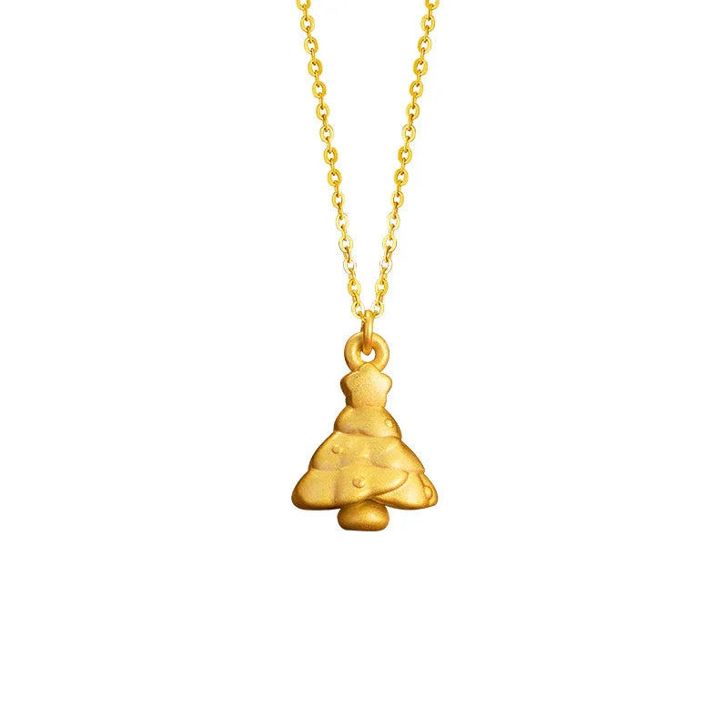A close-up image of a delicate necklace featuring a small gold Christmas tree pendant with a matte finish and subtle decorative details. The pendant hangs from a fine gold chain, showcasing a festive and elegant holiday design.