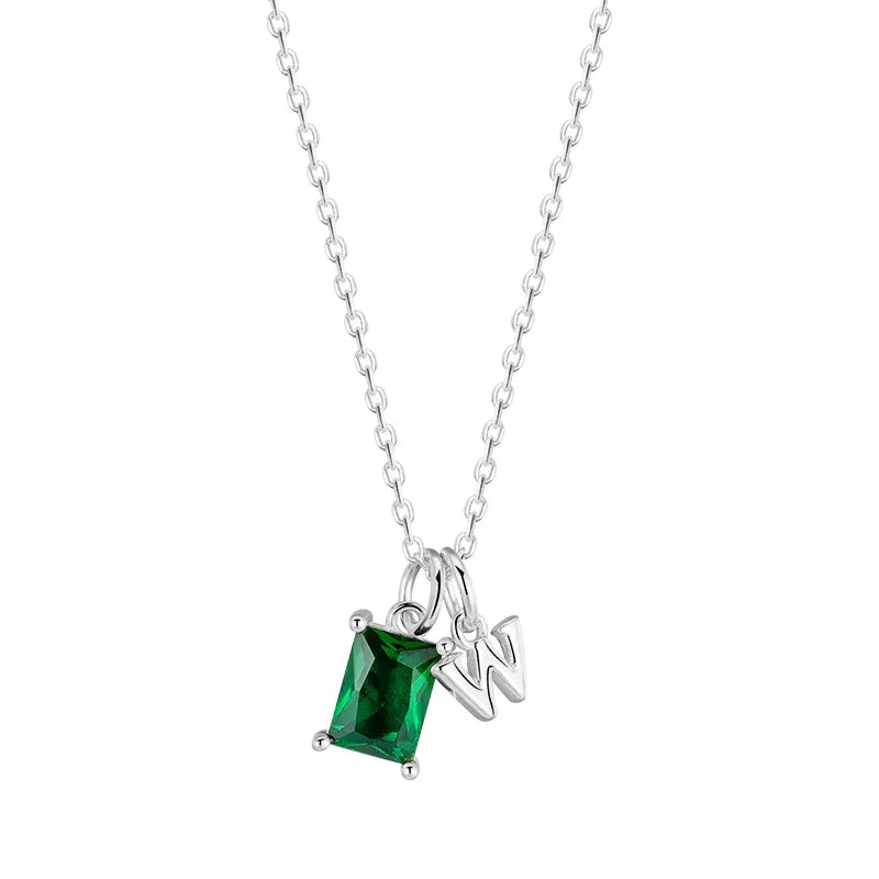 Silver necklace with a green gemstone pendant on a white background