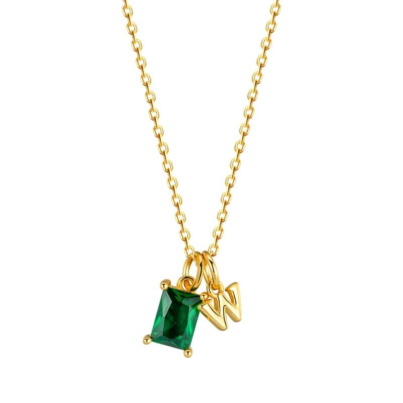 Gold necklace with a green gemstone pendant on a white background